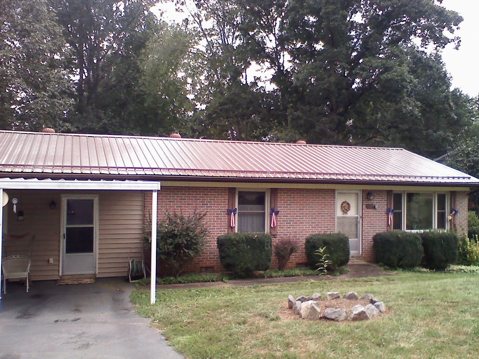 Bronze metal roof and carport on a brick ranch home — Roof Repair work by our crew in Maxwell